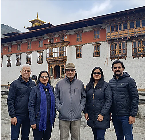 A family of five in the courtyard of a Bhutanese dzong on an Ayansh Holidays tour