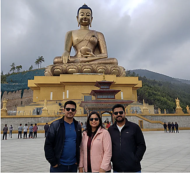 Three Ayansh Holidays travellers below the Buddha Dordenma statue in Thimphu